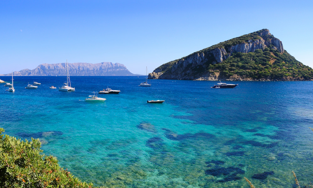 a view of isola di figarolo with isola tavolara in the background in golfo aranci sardinia