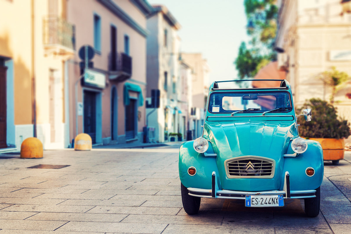 a picture of a citroen deux chevaux parked in the streets of Olbia, Sardinia, Italy