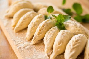 a picture of Culurgiones, a typical Sardinian ravioli filled with boiled potatoes, olive oil, pecorino cheese, garlic, and mint.