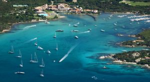 a picture of boats sailing in cala di volpe bay during high season