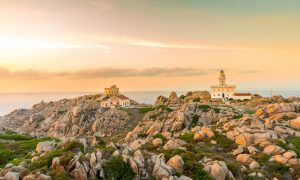 a picture of a sunset at il faro di capo testa in north sardinia