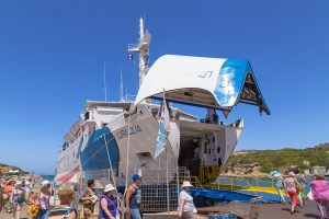 a picture of passengers entering a ferry from santa teresa di gallura to bonifacio corsica