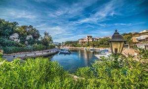 a picture of a boat in a canal in porto rotondo costa smeralda sardinia