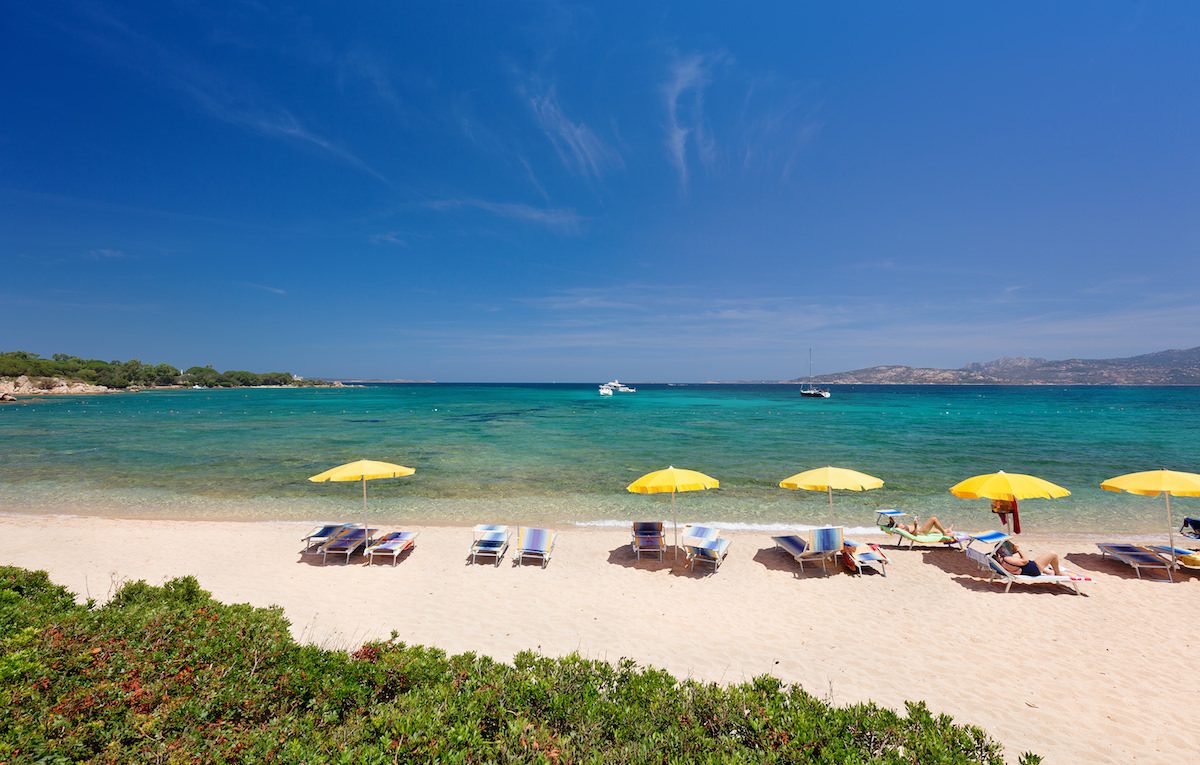 a picture of people on the beach of spiaggia mannena in cannigione north-east sardinia italy