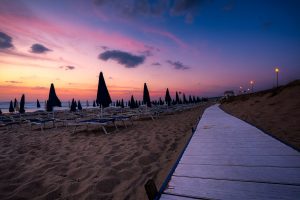 a picture of a beach near badesi taken at sunset