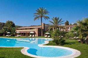 a picture of palm trees and lush green gardens at Hotel Aquadulci in Chia south Sardinia