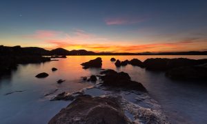 a picture of a warm sunset at the beach of punta don diego in north-east sardinia