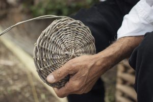 a picture of a sardinian man making a basket in castelsardo
