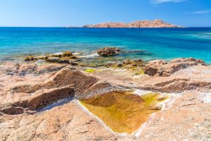 a picture of the red island situated in the waters near Isola Rossa in north Sardinia, Italy.