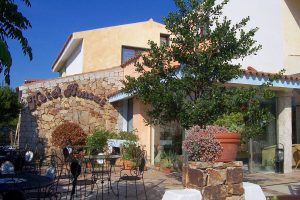 a picture of the entrance and terrace of Hotel Bonsai, a four-star hotel in San Teodoro, Sardinia, Italy.