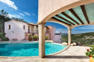 a picture of the sun terrace and swimming pool at Hotel Arathena in San Pantaleo, Sardinia, Italy.