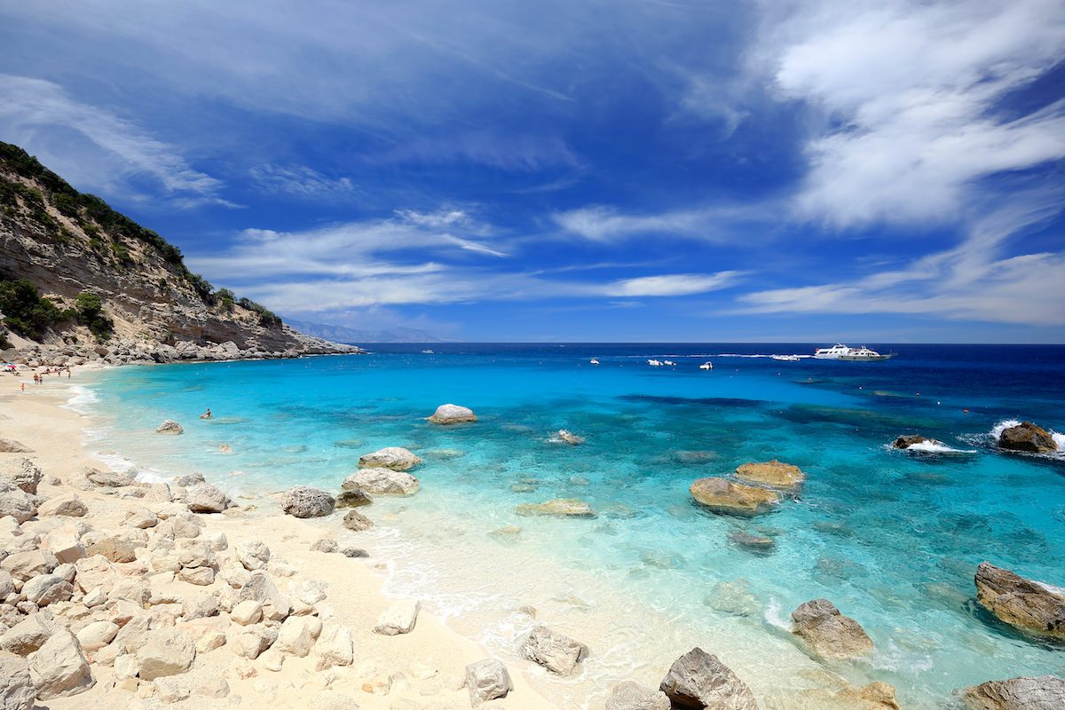 a picture of scattered rocks on the sandy beach of Cala dei Gabbiani, near Baunei, east Sardinia, Italy.