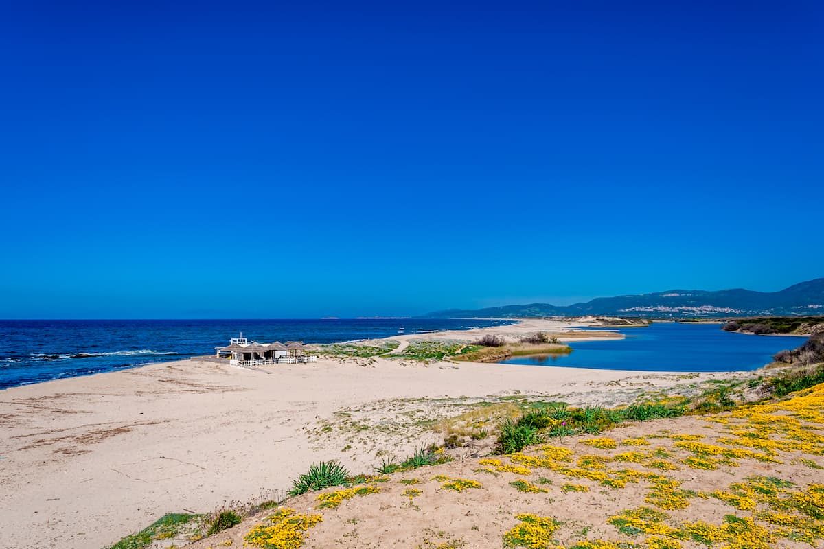 blues skies, a deep blue sea and a river at Spiaggia di San Pietro, in north Sardinia, Italy.