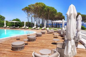 the outdoor pool and pine trees at boutique hotel la coluccia near santa teresa gallura, north sardinia, italy.