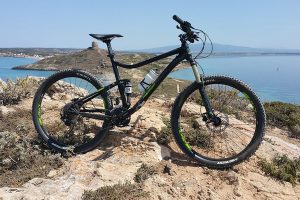 a scenic picture of the coast near Oristano, with a mountain bike in front.