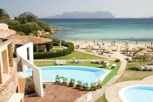 a view of the beachfront garden at hotel baia caddinas in golfo aranci