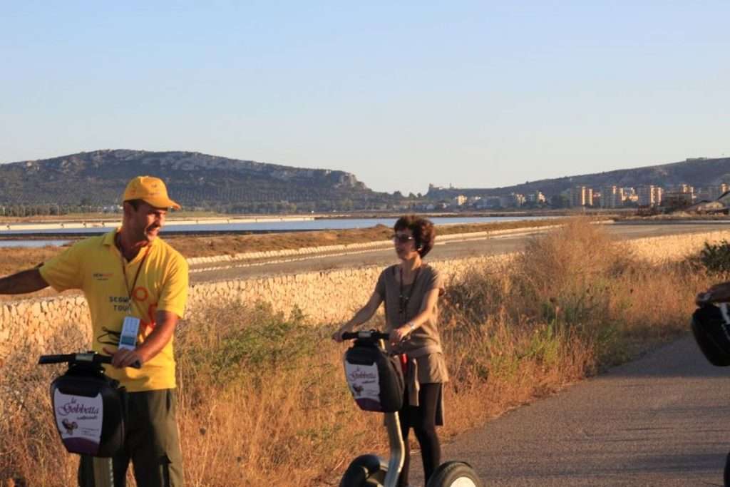 People exploring a pond in Cagliari on a Segway tour to see flamingos