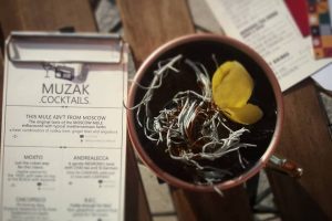 A drink menu with a Moscow Mule cocktail next to it.