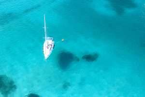 An aerial view of a sailboat exploring the waters of Sardinia, Italy.