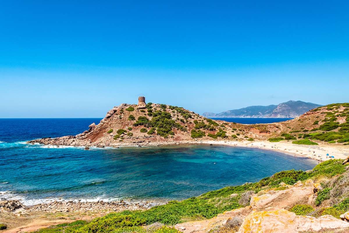 A view of the beach of Spiaggia di Porticciolo and its tower near Alghero, northwest Sardinia, Italy.
